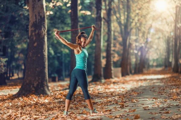 Женщина Растягивается Эластичной Группой Открытом Воздухе Осеннем Общественном Парке — стоковое фото