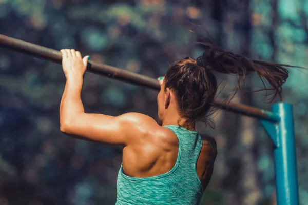 秋の公園で屋外鉄棒運動の女性 — ストック写真