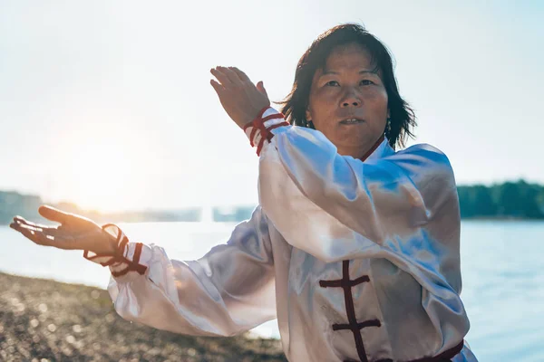 湖のほとりに太極拳の練習従来の衣類でアジアの女性 — ストック写真