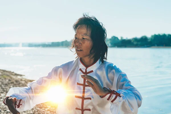 湖のほとりに太極拳の練習従来の衣類でアジアの女性 — ストック写真