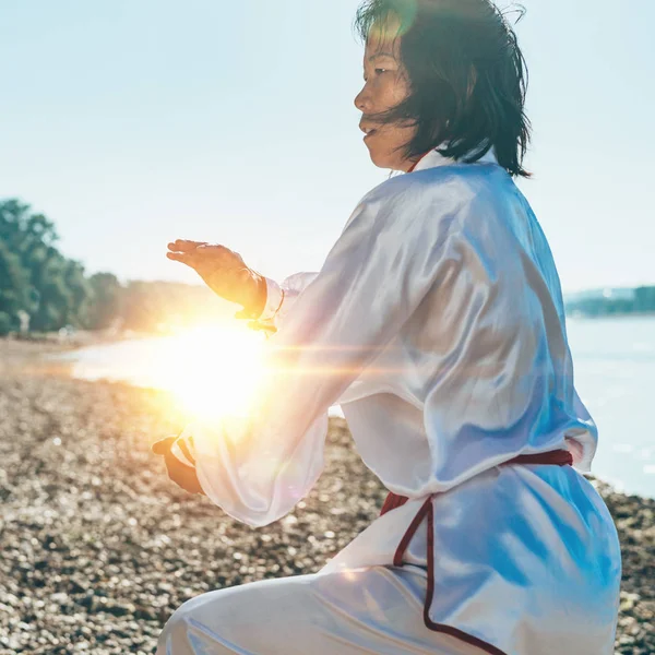 湖のほとりに太極拳の練習従来の衣類でアジアの女性 — ストック写真