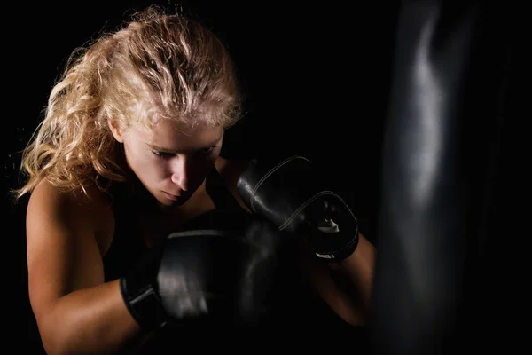 Blonde Woman Hitting Black Boxing Bag — Stock Photo, Image