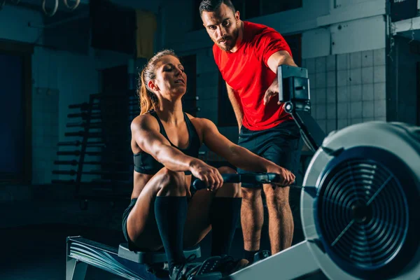 Eğitim Çapraz Kadın Atlet Kürek Makine Üzerinde Egzersiz Erkek Eğitmen — Stok fotoğraf