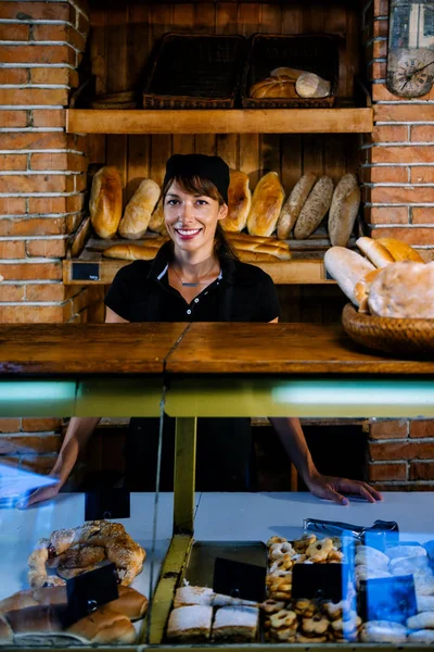 Bäckereifachverkäuferin Posiert Schwarzer Uniform Bäckerladen lizenzfreie Stockfotos