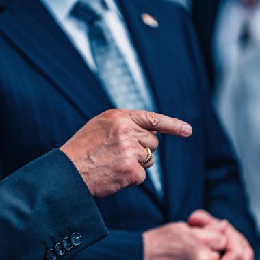 Yakın işadamı grubu giymiş olarak takım elbise ve kravat. Erkek el üzerinde odaklanmak, işaret parmak. 