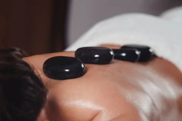 Jonge Vrouw Getting Hot Stone Massage Spa Salon Liggend Een — Stockfoto