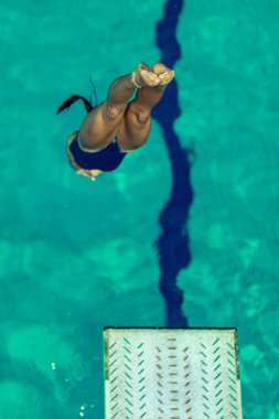 Kadın dalgıç dalış tahtasından havuza atlama