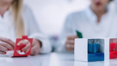 İki kadın mum üreticileri mum Mağazası içinde mum kokulu beyaz palto giymiş.   