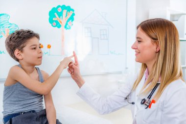 Çocuk doktoru muayene çocukla yapıyor