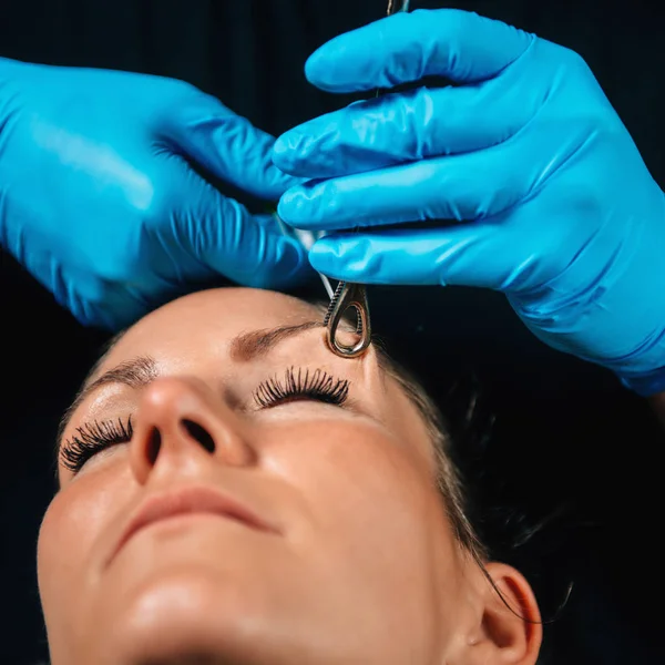 Schöne Junge Frau Bekommt Ihr Augenbrauenpiercing Körperpiercer Trägt Blaue Handschuhe — Stockfoto