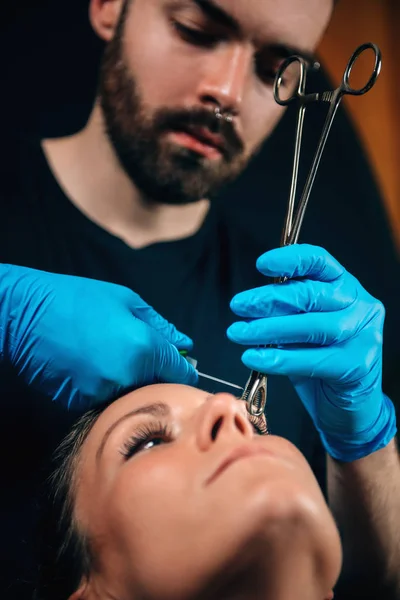 Schöne Junge Frau Bekommt Ihr Augenbrauenpiercing Körperpiercer Trägt Blaue Handschuhe — Stockfoto