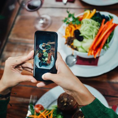 Genç kadın lezzetli vejetaryen burger ve karışık organik salata Vejetaryen restoran beyaz plaka üzerinde çekim görüntüsü kare.