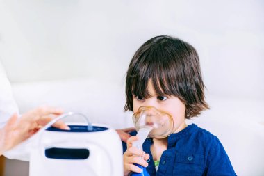 Boy using respiratonic inhaler  