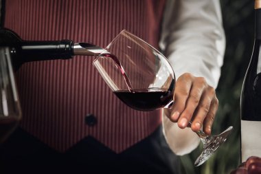 Kadın sommelier şarap cam içine kırmızı şarap dökme.