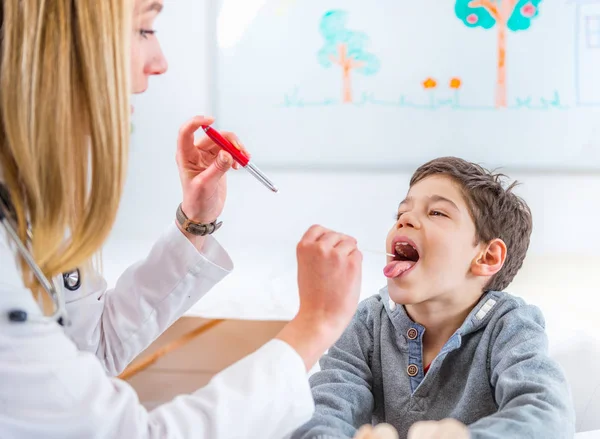 Kinderarzt Untersucht Jungen Mit Taschenlampe Und Zungendepressor — Stockfoto