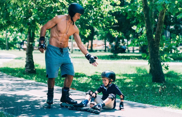 Grootvader Zijn Kleinzoon Helpen Roller Skating Ongeval — Stockfoto