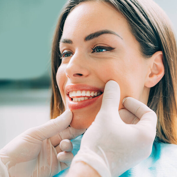 Young smiling woman with beautifiul teeth, having a dental inspection