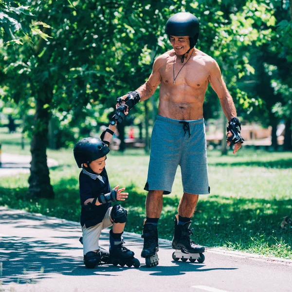 Dziadek Pomagając Jego Wnuk Incydencie Rollerskating Drobne — Zdjęcie stockowe