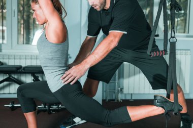 Kişisel antrenör ile jimnastik salonu kadın trx üzerinde egzersiz