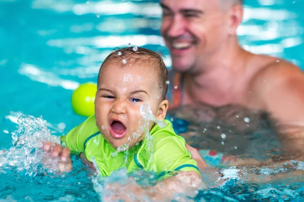 父亲与男婴在游泳池游泳课 — 图库照片