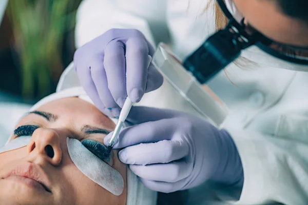 Kosmetikerin Mit Schwarzer Farbe Auf Die Wimpern Während Der Wimpernstraffung — Stockfoto