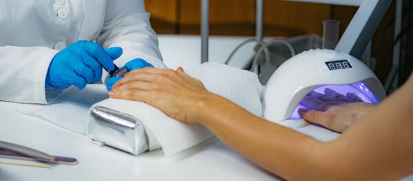Woman Getting Nail Manicure Paint in Beauty Salon.