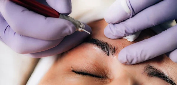 Beautician Microblading Eyebrows in Beauty Salon