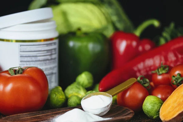 콜라겐 단백질은 플라스틱 숟가락과 신선한 다채로운 채소를 테이블에 용기에 파우더를 — 스톡 사진