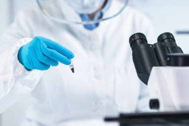 Antik DNA analizi. Antik DNA laboratuvarında örnek li mikro tüp tutan kadın bilim adamı