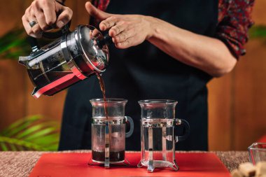 Fransız Basın Kahvesi. Cam kahve bardağına Fransız basın kahvesi döken kadın barista nın elleri