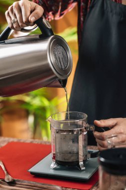 Fransız Basın Kahvesi. Barista Fransız basın tenceresine su ısıtıcısı kaynar su dökerek ve demleme den önce ölçekte tartma.