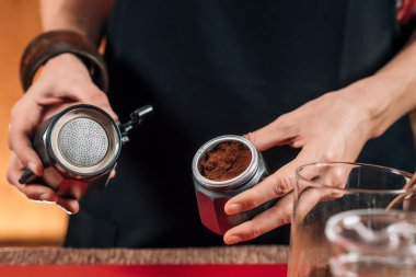 Sotovetop Moka Pot ile Kahve Yapma. Kadın Barista Stovetop Moka Pot zemin kahve koyarak