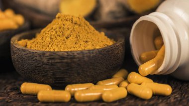 Curcumin bitkisel ek kapsül ve cam kase zerdeçal tozu. Anti-inflamatuar bitkisel ilaç (Curcuma) 