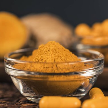Curcumin bitkisel ek kapsül ve cam kase zerdeçal tozu. Anti-inflamatuar bitkisel ilaç (Curcuma) 
