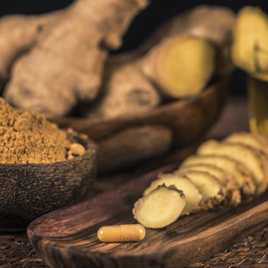 Zencefil bitkisel ek kapsül, zencefil zemin baharat tozu, çay, ve masada taze dilimlenmiş kök. İltihapkarşı bitkisel ilaç