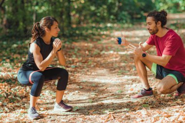Lastik Direniş Grubu ile parkta egzersiz yapan genç bir çift.