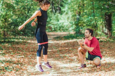 Lastik Direniş Grubu ile parkta egzersiz yapan genç bir çift.