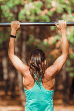 Parkta barfiks çeken bir kadın.  