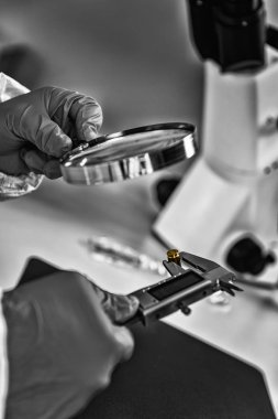 Adli Tıp Laboratuvarda. Adli tıp teknisyeni mermi kovanını inceliyor.