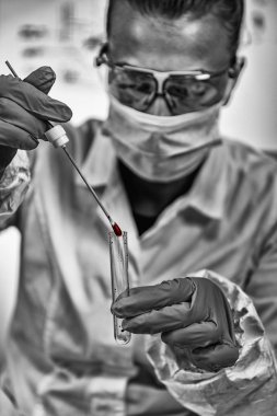 Adli tıp uzmanı kan lekesinden DNA topluyor.