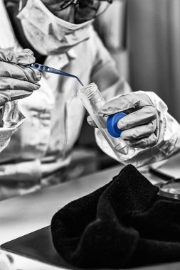 Adli Tıp Laboratuvarı. Adli tıp uzmanı saçı inceliyor, DNA arıyor.