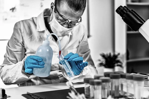 Adli Tıp Laboratuvarı. Adli tıp uzmanı saçı inceliyor, DNA arıyor.