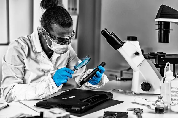 Adli tıp verileri. Adli analist dizüstü bilgisayarı inceliyor.