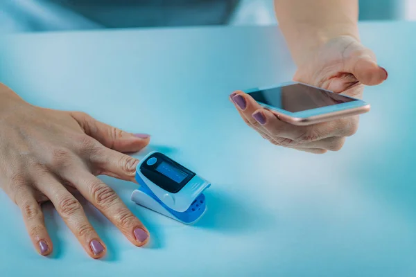 Nabız Oksimetresi Akıllı Telefon Kullanan Kadın Oksijen Doygunluğunu Ölçüyor — Stok fotoğraf