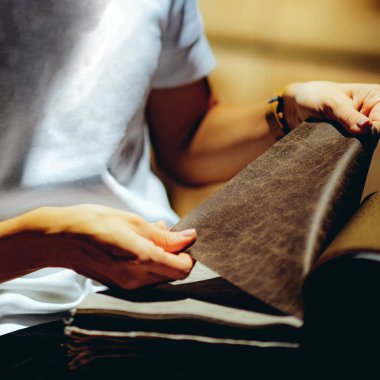 Ev tasarım salonundaki kumaş örneklerine bakan kadın dekoratör.