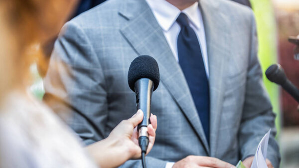 Media Interview - journalists with microphones interviewing formal dressed politician or businessman.