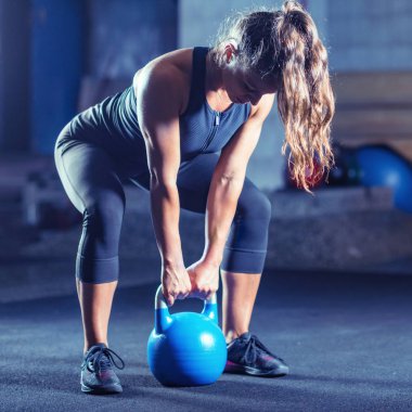 Kadın atlet kettlebell ile kapalı egzersiz