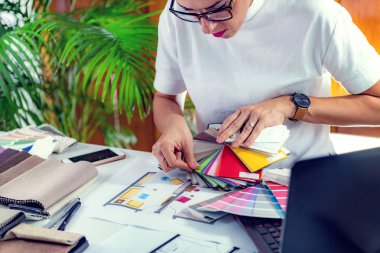 Mimar, iç mimar, ofiste malzeme örnekleme tahtasıyla çalışıyor.