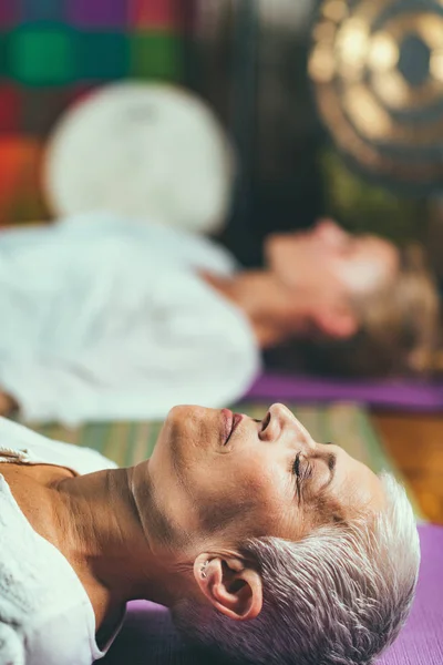 ガイド付き瞑想療法 年配の女性が瞑想して床に横になって — ストック写真