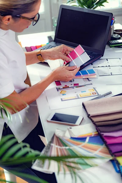 Kadın iç mimar stüdyoda renk numunesi olarak frenk rengi seçiyor